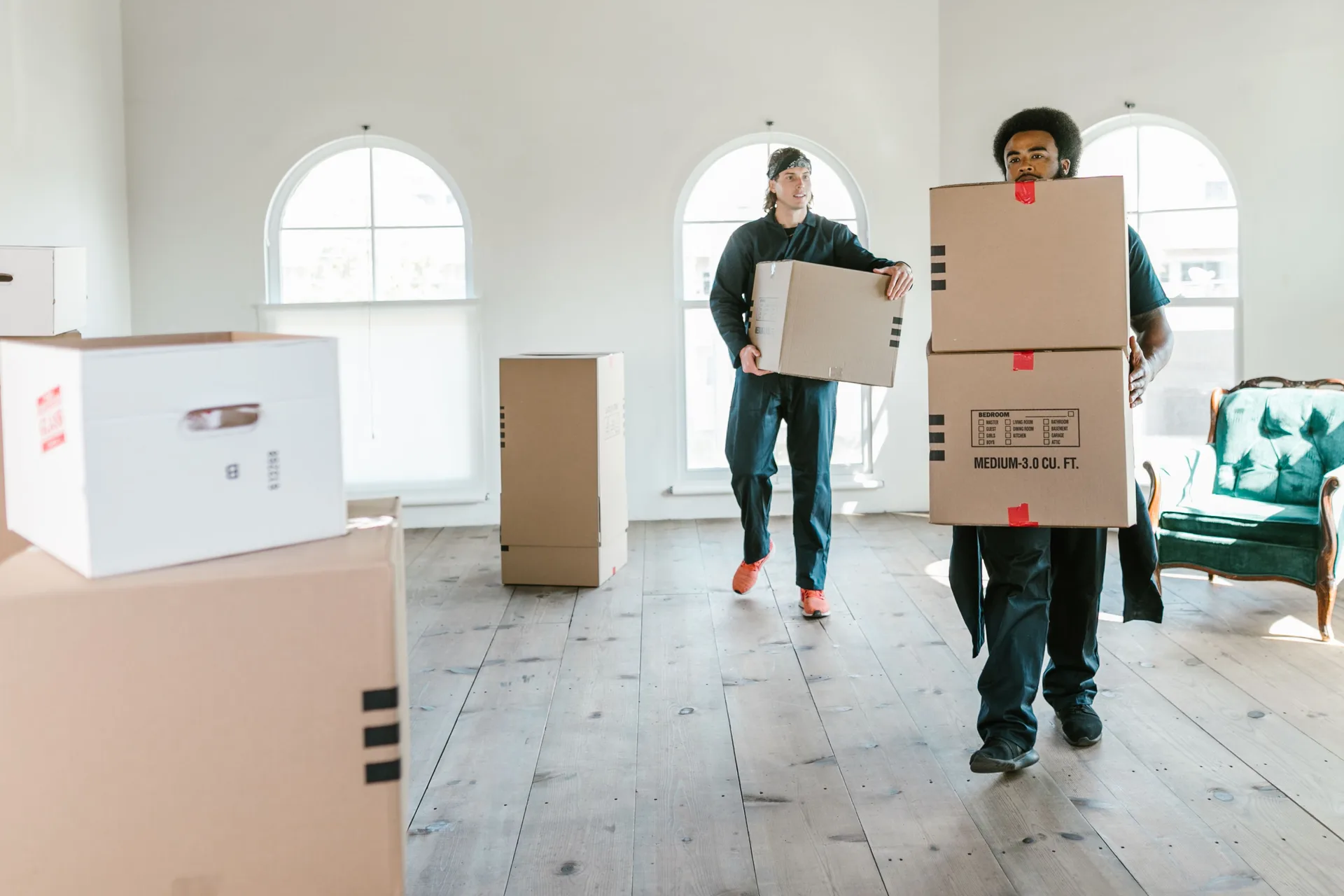 Twee medewerkers dragen samen verhuisdozen tijdens een ontruiming